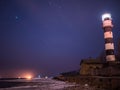 Black and white lighthouse at night in Baltic sea beach Royalty Free Stock Photo