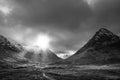 Black and white Majestic Winter landscape image of Etive Mor in Scottish Highlands with sunbeams streaming down between the Royalty Free Stock Photo