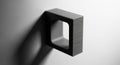 Black and white minimalist square object hanging on plain white wall with subtle shadow and textured surface Royalty Free Stock Photo