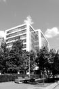 Black and white modern office building with trees and park benches Royalty Free Stock Photo