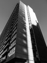 Black and white monochrome image looking up at a tall apartment building on a clear sunny day with vertical Royalty Free Stock Photo