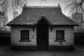 Brick building with one black door, two windows and slate roof Royalty Free Stock Photo