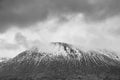 Black and white Moody Winter landscape image of Beinn AÃ¢â¬â¢ Chaladair in Scotland with dramatic skies overhead