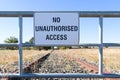 Black and white No Unauthorised Access warning sign on the fence of a disused railway line Royalty Free Stock Photo