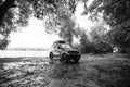 Black and white. off-road vehicle on the shore of a lake, parking in the forest in the middle of wilderness. Without recognition. Royalty Free Stock Photo