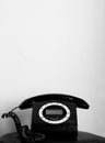 Black and white old/vintage looking telephone on black table with enough space to write Royalty Free Stock Photo