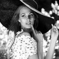 Black-white outdoor portrait of beautiful young blonde woman in black classic hat Royalty Free Stock Photo