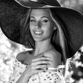 Black-white outdoor portrait of beautiful young blonde woman in black classic hat Royalty Free Stock Photo