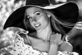 Black-white outdoor portrait of beautiful young blonde woman in black classic hat Royalty Free Stock Photo