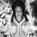 Black-white outdoor portrait of beautiful young blonde woman in black classic hat Royalty Free Stock Photo