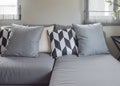 Black and white parallelogram pattern pillows on gray L shape sofa Royalty Free Stock Photo