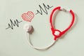 Black and white phot of toy stethoscope and colorful heart beats illustration over textured background