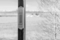 Black and white photo of an analog thermometer mounted outside