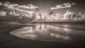 A black and white photo of a beach with clouds in the sky, AI Royalty Free Stock Photo
