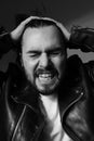 Black and white photo of bearded screaming brutal man. Vertical.