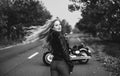 Black and white photo of beautiful biker women posing with motorcycle. Royalty Free Stock Photo