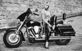 Black and white photo of beautiful biker women posing with motorcycle.