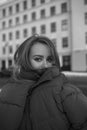 Black and white photo of beautiful funny girl in huge jacket