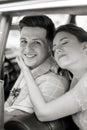 Black and white photo of beautiful young bride and smiling handsome groom in the retro car Royalty Free Stock Photo