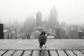 a black and white photo of a bird standing on a ledge in front of a city Royalty Free Stock Photo