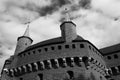 Black and white photo of a brick building with two towers against the sky. Royalty Free Stock Photo