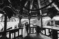 black and white photo. The bride and groom stand in a retro gazebo.