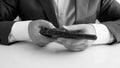 Black and white image of businessman holding revolver in hands