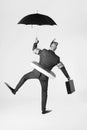 Black and white photo of businessman in swimming gear holding briefcase and umbrella Royalty Free Stock Photo