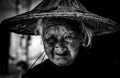 Black and white photo of a Chinese elderly woman wearing an old bamboo straw hat is going to farm in Zhangzhou, Fujian