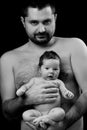 Black and white photo. Dad holding in his hands little newborn baby. Father's love