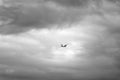 Black and white photo of a dangerous airplane flying in dark clouds