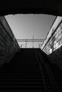 A black-and-white photo of the exit from an old and dark stone tunnel ending in a staircase. Royalty Free Stock Photo