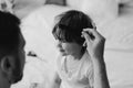 Black and white photo. Father cuts her son hair in the room. Family during quarantine, Scissors and a comb in male hands