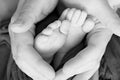 Black and white photo of the feet of a child in the arms of the mother. Macro shot. Mom and her baby. Concept of a happy family Royalty Free Stock Photo