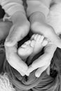 Black and white photo of the feet of a child in the arms of the mother. Macro shot. Mom and her baby. Concept of a happy family Royalty Free Stock Photo