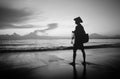 Black and white photo of fisherman standing by the sea