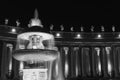 Black and white photo of fountain at St. Peter`s Square in Vatican at night