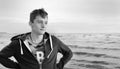 Black and white photo. Free happy young man standing on the beach feeling the warm wind looking into the distance, relaxed and Royalty Free Stock Photo