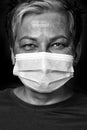 Black and white photo. Happy eyes smiling grey short haired doctor woman wearing medical face mask looking at camera Royalty Free Stock Photo