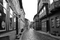 Black and white photo from a historical cobblestone alley with half-timbered houses