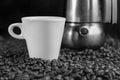 Black and white photo with a italian espresso machine coffee beans and a white cup on dark background Royalty Free Stock Photo