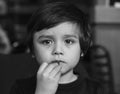 Black and white photo of kid eating chocolate, Close up face of Little boy lost in thought looking out the window while eating cho Royalty Free Stock Photo