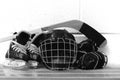 Black and white photo of kid`s hockey gear: helmet, stick, gloves, skates