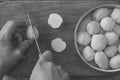 Black and white photo man cook potato slices with a kitchen knife on a cutting board Royalty Free Stock Photo