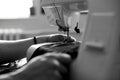 Black and white photo of Man sews clothes on sewing machine