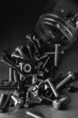 Black and white photo of a mason jar full of nuts and bolts spilled out onto a wooden table