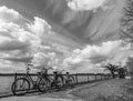 Black and white photo of 3 parked bicycles and a cloudy sky Royalty Free Stock Photo