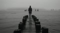 a black and white photo of a person standing on a pier