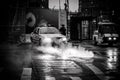 Black and White Photo of a Police Vehicle with its Headlights Shed Light on Steam Cominf of the Sewers in Lower Manhattan, New Yor