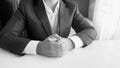 Black and white image of politician in suit sitting in office behind desk Royalty Free Stock Photo